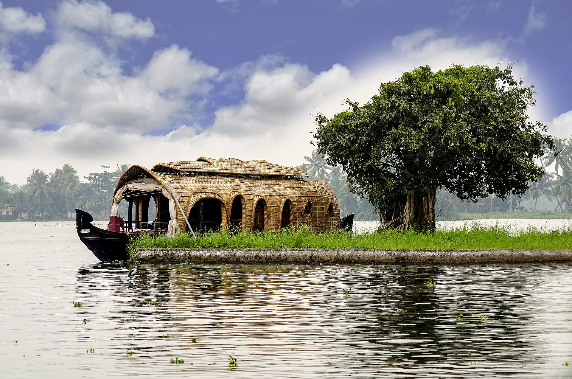 Traditional wooden houseboat cruising tranquil Kerala backwaters